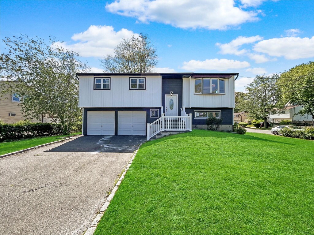 1580 Brentwood Rd, Bay Shore, NY 11706 - bi-level home featuring driveway, a front yard, and an attached garage