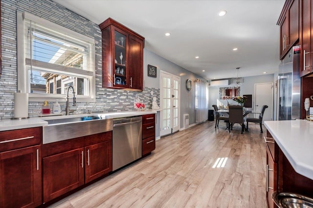 1075 Frances Dr, Valley Stream, NY 11580 - kitchen with stainless steel appliances, reddish brown cabinets, light countertops, healthy amount of natural light, and recessed lighting