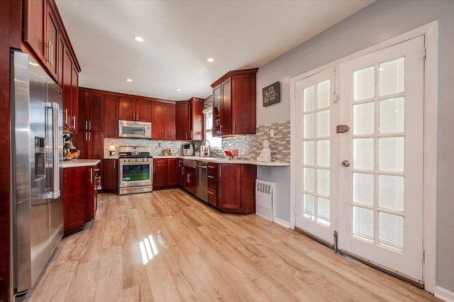 1075 Frances Dr, Valley Stream, NY 11580 - kitchen with appliances with stainless steel finishes, light countertops, radiator, backsplash, and recessed lighting