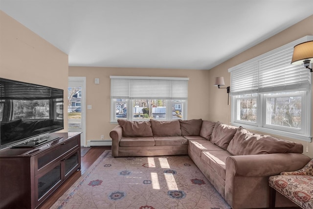living area featuring a baseboard heating unit and wood finished floors