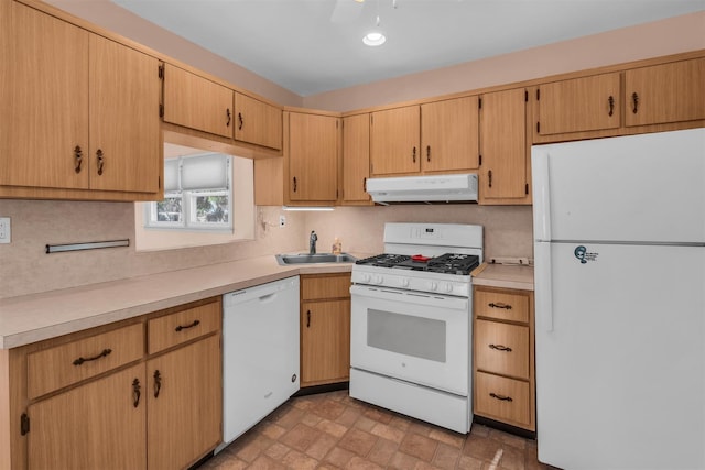 kitchen with under cabinet range hood, white appliances, light countertops, and a sink