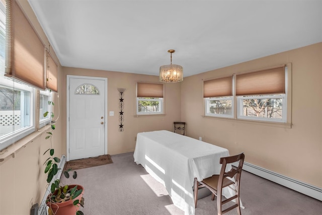 dining room with a baseboard radiator, carpet, and a notable chandelier