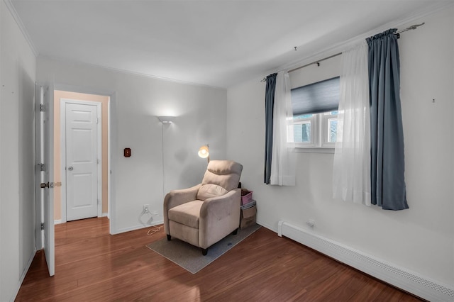 living area with baseboards, baseboard heating, wood finished floors, and ornamental molding