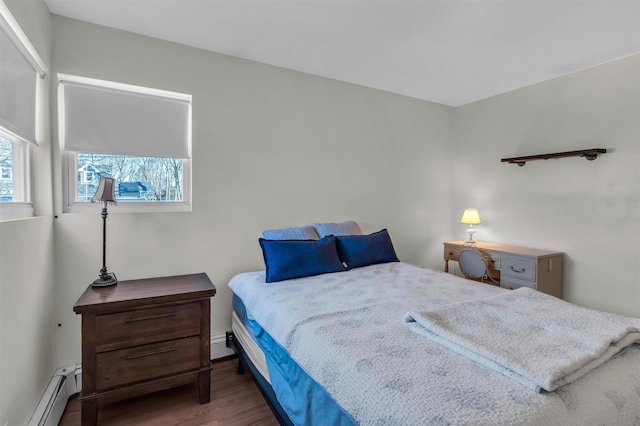 bedroom with baseboard heating, a baseboard radiator, and wood finished floors