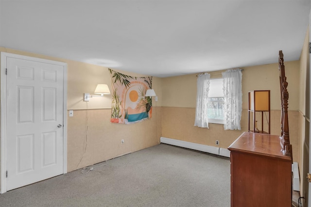 spare room featuring carpet, wainscoting, and a baseboard radiator