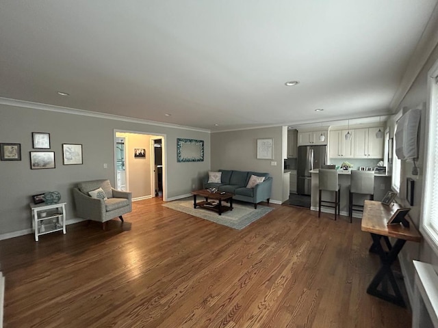 living area featuring dark wood-style flooring, ornamental molding, and baseboards