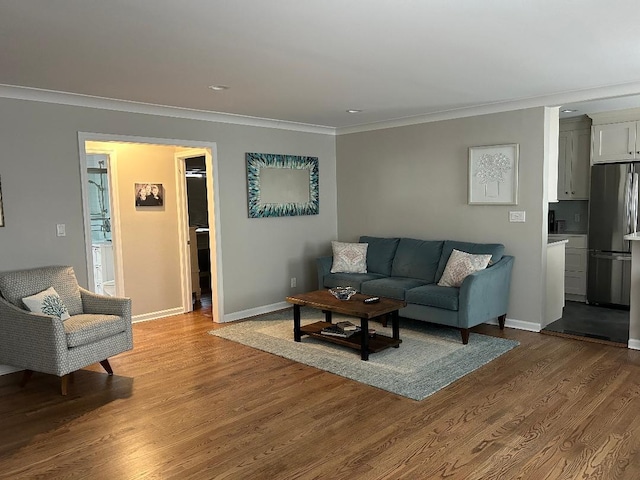 living area featuring crown molding, baseboards, and wood finished floors