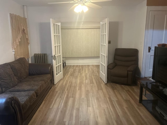 living room featuring a ceiling fan, radiator heating unit, french doors, and wood finished floors