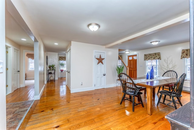 dining room featuring stairway, baseboards, and light wood-type flooring