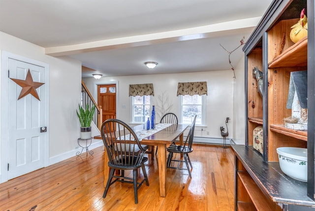 dining room featuring baseboards, baseboard heating, stairs, and light wood finished floors