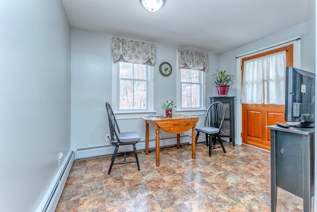 dining space with stone finish flooring, baseboards, and baseboard heating