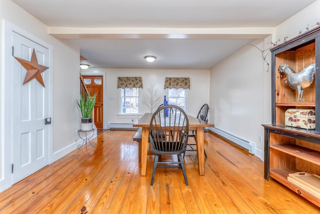dining room with light wood finished floors, baseboards, and a baseboard radiator