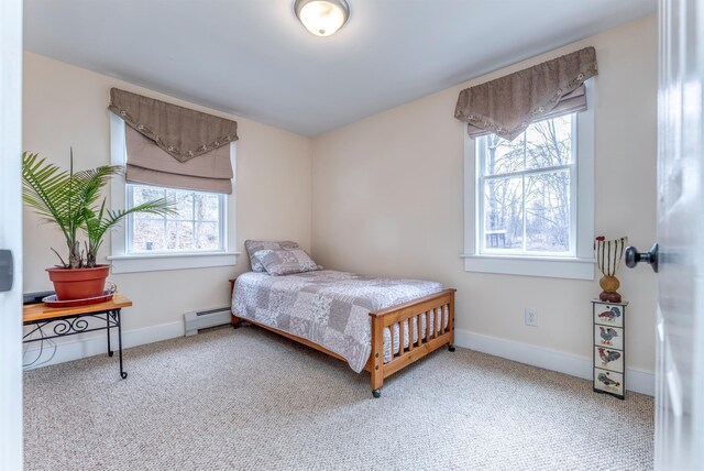 carpeted bedroom with a baseboard heating unit and baseboards
