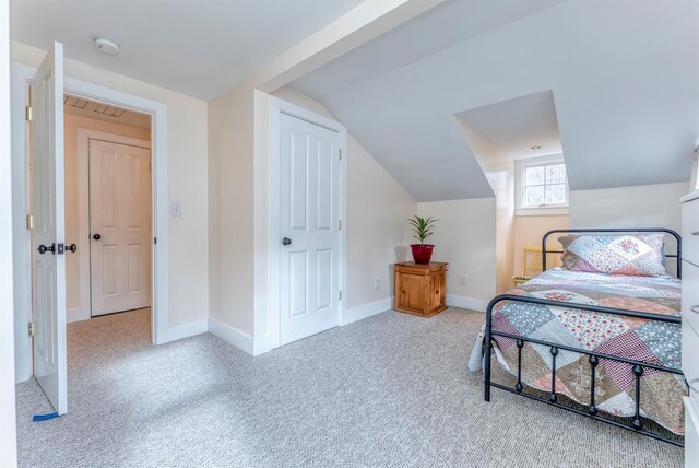bedroom featuring baseboards, lofted ceiling, and carpet