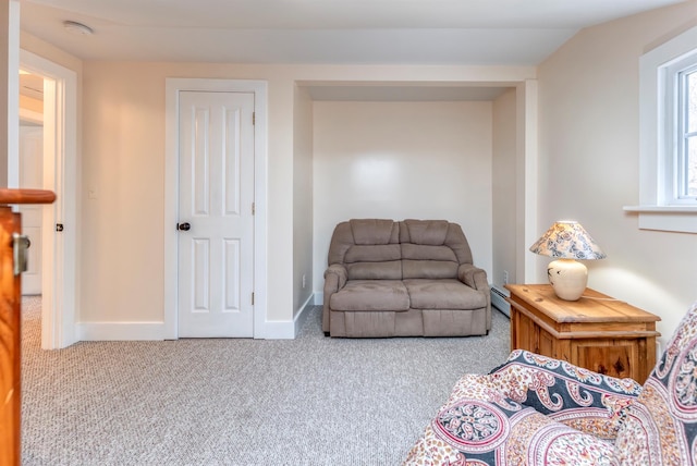 living area with a baseboard heating unit, baseboards, and carpet floors