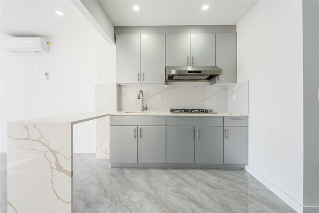 941 57th St Unit 4B, Brooklyn, NY 11219 - kitchen with an AC wall unit, gray cabinets, under cabinet range hood, and a sink
