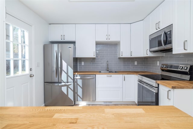 181 Vernon Valley Rd, East Northport, NY 11731 - kitchen featuring wood counters, stainless steel appliances, a sink, and decorative backsplash