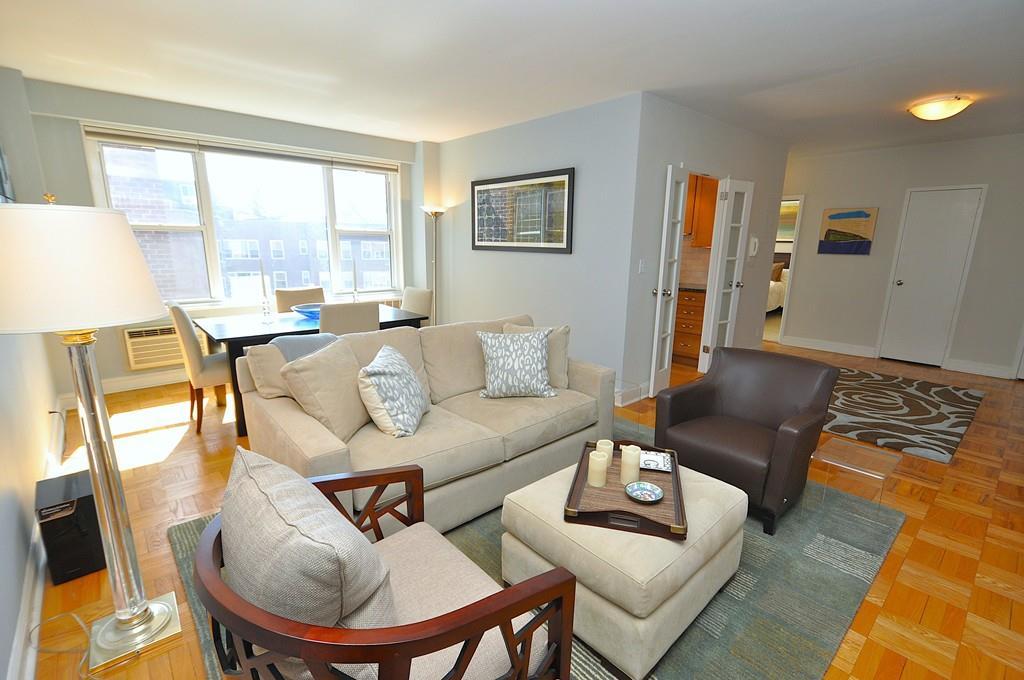 living area with baseboards and a wall mounted air conditioner