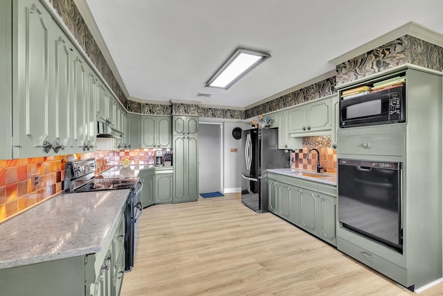 kitchen featuring oven, black microwave, a sink, electric range oven, and green cabinets