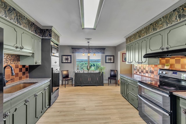 kitchen featuring double oven range, tasteful backsplash, a sink, green cabinets, and under cabinet range hood