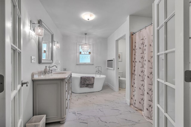 full bathroom featuring an inviting chandelier, vanity, toilet, marble finish floor, and a soaking tub