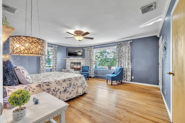 bedroom featuring crown molding, multiple windows, wood finished floors, and visible vents