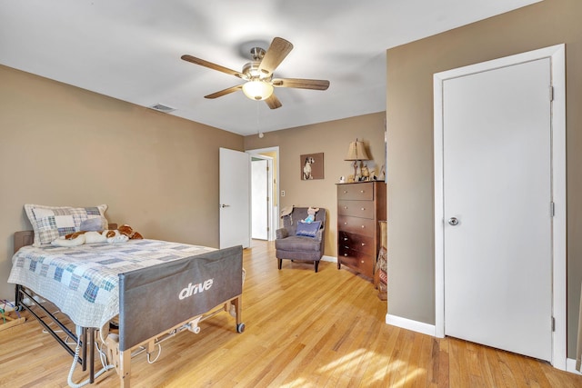 bedroom featuring a ceiling fan, baseboards, visible vents, and light wood finished floors