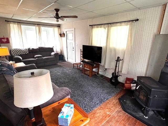 191 Gables Rd, Narrowsburg, NY 12764 - living area featuring a wood stove, a ceiling fan, a paneled ceiling, and wood finished floors
