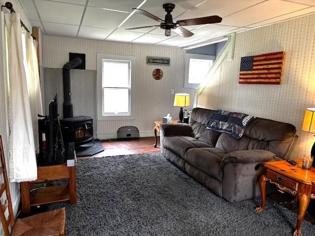 191 Gables Rd, Narrowsburg, NY 12764 - living room with a ceiling fan, a wood stove, wallpapered walls, and carpet floors