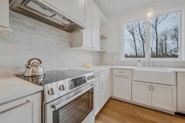 550 Madison Ave, Greenport, NY 11944 - kitchen with electric range, custom exhaust hood, a sink, decorative backsplash, and open shelves