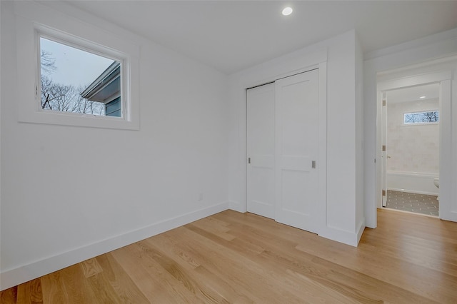 550 Madison Ave, Greenport, NY 11944 - unfurnished bedroom featuring light wood finished floors, a closet, baseboards, and recessed lighting