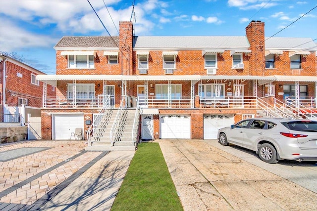 view of front facade featuring driveway, a chimney, and a garage