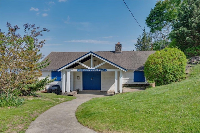 view of front of property with a shingled roof, a chimney, and a front lawn