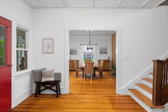 interior space with an inviting chandelier, stairway, and light wood-style flooring