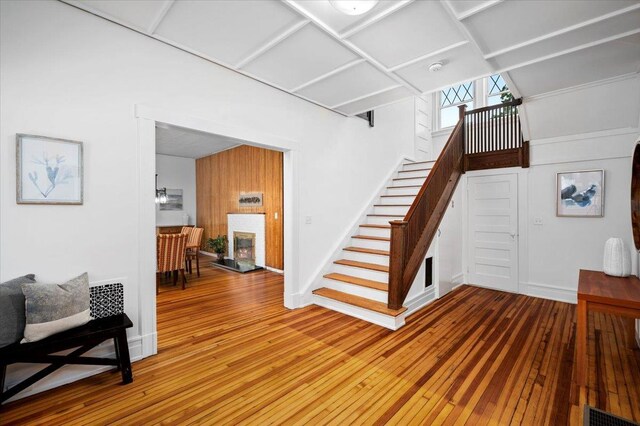 interior space featuring wood-type flooring, baseboards, visible vents, and a glass covered fireplace