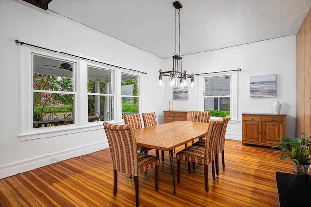 dining room with a chandelier, baseboards, and wood finished floors