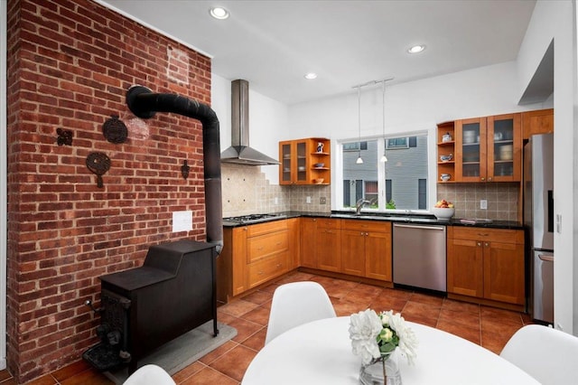 kitchen with glass insert cabinets, open shelves, dark countertops, wall chimney range hood, and appliances with stainless steel finishes