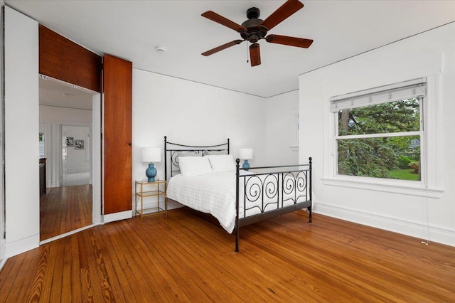 bedroom featuring hardwood / wood-style flooring, baseboards, and a ceiling fan