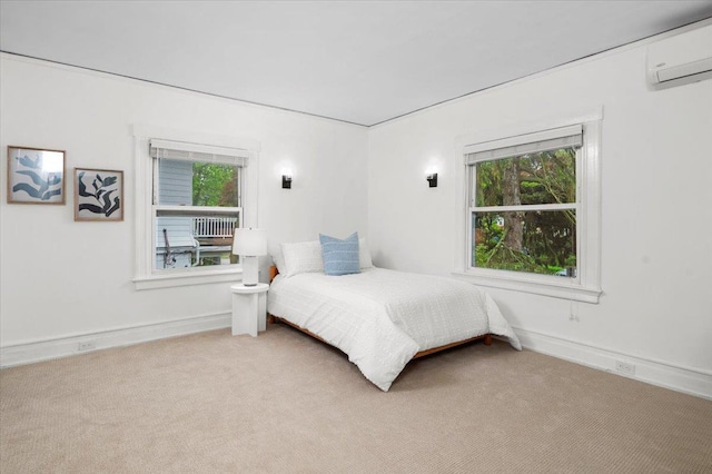 carpeted bedroom with multiple windows, baseboards, and an AC wall unit