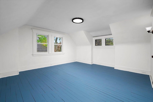 bonus room featuring dark wood finished floors, vaulted ceiling, and baseboards