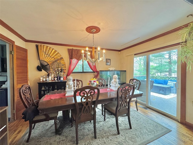 15 Highland Ave, Chestnut Ridge, NY 10977 - dining room with a wealth of natural light, wood finished floors, a notable chandelier, and crown molding