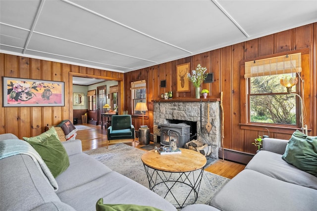 35 Riverview Trl, Croton-On-Hudson, NY 10520 - living room with light wood-style flooring, wood walls, a baseboard radiator, and a wood stove