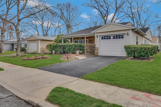 ranch-style home featuring stone siding, a front yard, driveway, and a garage