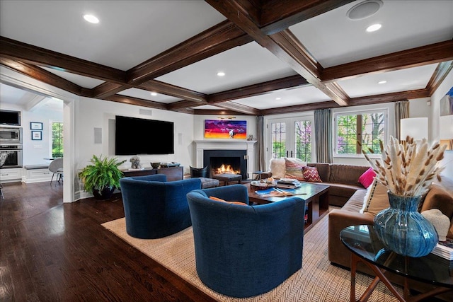 living room featuring a wealth of natural light, a warm lit fireplace, beam ceiling, and dark wood-type flooring