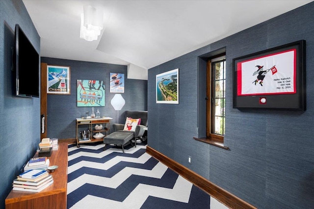 living area with tile patterned floors, baseboards, and vaulted ceiling