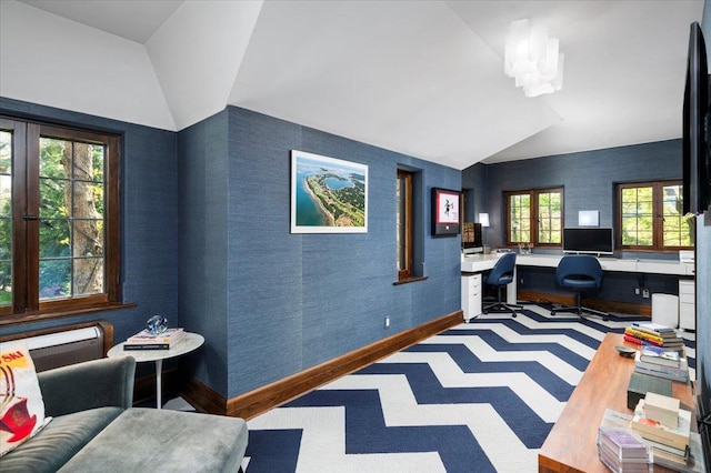 office featuring baseboards, built in desk, lofted ceiling, and wallpapered walls