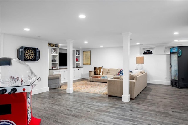 living room featuring recessed lighting, decorative columns, and wood finished floors