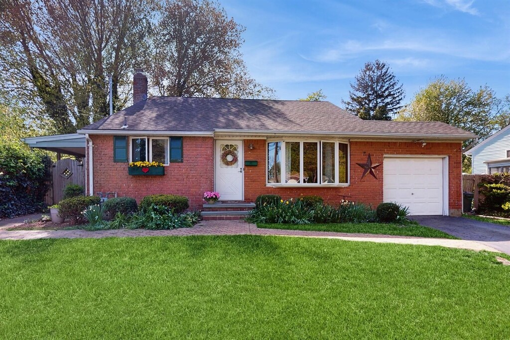 17 Longley Pl, Huntington Station, NY 11746 - single story home featuring a front yard, a chimney, brick siding, an attached garage, and driveway