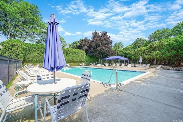 community pool with fence and a patio