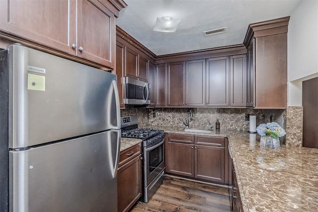903 Sara Cir Unit 903, Port Jefferson Station, NY 11776 - kitchen with appliances with stainless steel finishes, a sink, dark wood-style flooring, tasteful backsplash, and light stone countertops